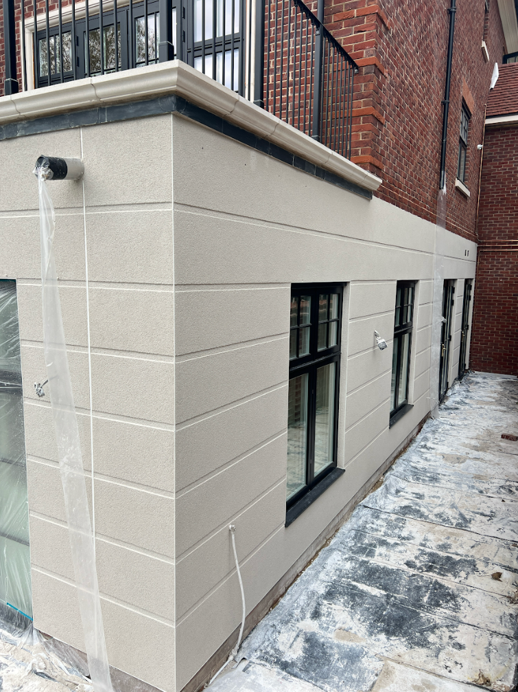 Rendering specialist performing a final quality inspection on a newly rendered house exterior to ensure long-lasting performance